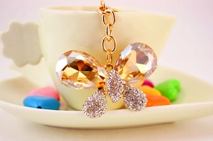 Détail de porte-clés papillon en or avec ailes en cristal champagne et diamants fins