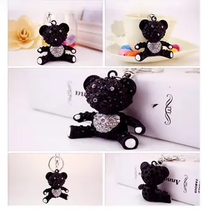 Detailed views of a black rhinestone bear keychain with a white crystal heart detail
