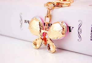 Détail du porte-clés papillon en métal avec des accents superposés rose et argent