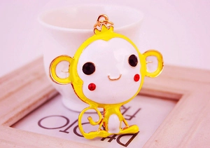 Detailed view of the cartoon monkey keychain with yellow oil drip and rhinestone eyes