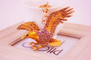 Detailed close-up of golden eagle keychain pendant featuring crystal rhinestones