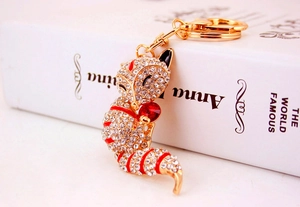 Detail of crystal fox keychain featuring white rhinestones and a red center gem