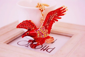 Close-up of eagle keychain with red rhinestones on a gold-plated metal base