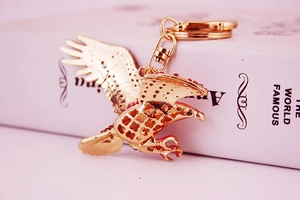 Macro detail of golden eagle keychain with intricate wing patterns and crystal accents