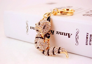 Detailed view of crystal-encrusted raccoon keychain with gold-plated metal finish