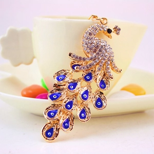 Golden peacock keychain with sparkling white rhinestones and blue evil eye charms