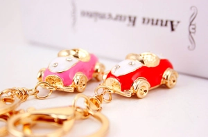 Detail of red and pink car keychains with gold plating and sparkling crystal accents