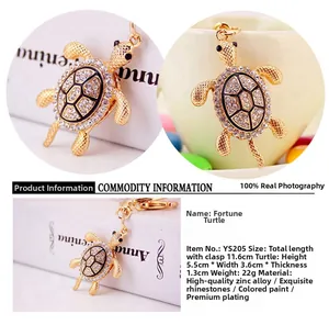Détail d'un porte-clés tortue doré orné de strass blancs et de textures en émail noir