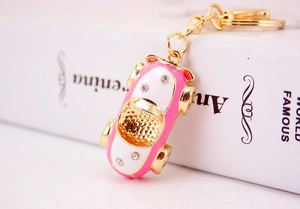 Detail of creative pink enamel car keychain with sparkling crystals and gold clasp