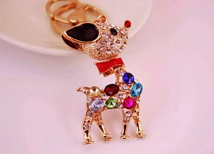 Close-up of golden deer keychain with multi-colored crystals and red scarf detail