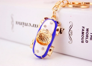 Close-up of blue car keychain with sparkling crystals and gold-plated lobster clasp detail