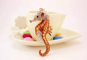 Détail d'un porte-clés hippocampe orné de strass brillants et d'un émail orange vif