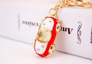 Close-up of red and white cartoon car keychain with crystal rhinestones and gold ring
