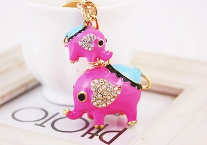 Gros plan sur porte-clés éléphant rose avec strass en cœur et chaîne en métal doré