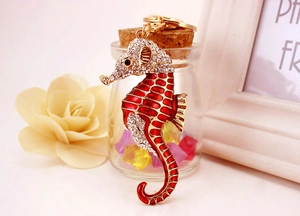 Détail du porte-clés hippocampe doré avec émail rouge et strass brillants sur le corps