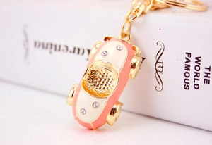 Close-up of pink cartoon sports car keychain with crystals and gold lobster clasp