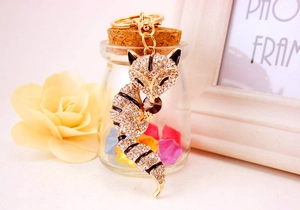 Detail of crystal fox keychain with white rhinestones and gold plating on decorative background