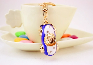 Blue and white sports car keychain with crystals hung on a ceramic cup edge