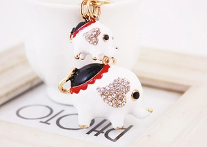 Détail du porte-clés éléphant mère et bébé avec strass et émail sur une tasse blanche