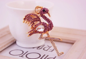 Vue détaillée du porte-clés flamant rose avec strass sur un support en métal doré