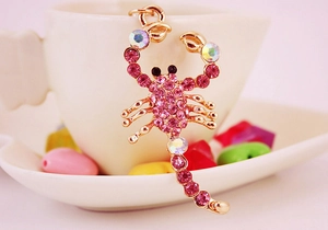 Macro shot of pink rhinestone scorpion keychain with sparkling crystals and gold finish
