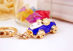 Close-up of a golden car keychain with blue enamel and sparkling crystal accents