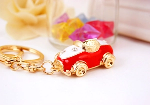Close-up of red vintage convertible car keychain with rhinestones and enamel finish
