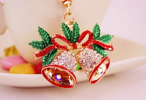 Detailed close-up of Christmas bell keychain with sparkling rhinestones and red enamel bow