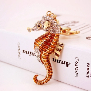 Porte-clés hippocampe doré avec cristaux brillants et détails en émail orange vif
