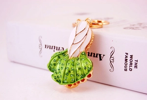 Detail view of cabbage keychain with green rhinestones and white enamel finish
