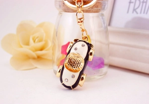 Close-up of golden beetle car keychain with black enamel and sparkling rhinestones