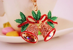 Macro view of Christmas bells keychain with sparkling red rhinestones and holly leaves