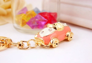 Macro view of pink sports car keychain with gold hardware and sparkling rhinestone accents