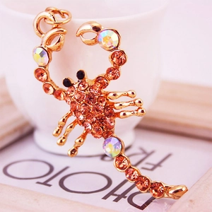 Golden scorpion keychain pendant with orange rhinestones and rainbow crystal accents
