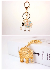 Detail showing the white enamel elephant keychain with colorful beads and gold cutout design