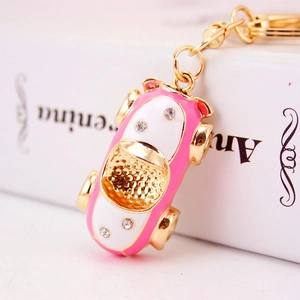 Pink and white metal car keychain with gold plating and sparkling crystal accents