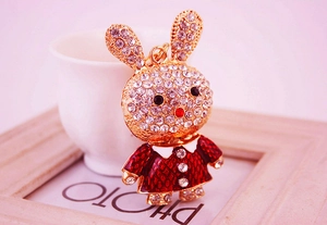 Détail d'un porte-clés lapin en strass brillant avec robe à carreaux rouges et dorure