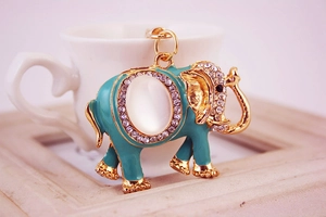 Détail du porte-clés éléphant doré avec émail bleu et incrustation de pierre d'opale