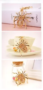 Detailed close-up of a sparkling spider keychain featuring gold metal and rhinestones
