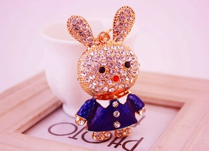Détail d'un porte-clés lapin étincelant avec robe en émail bleu et cristaux de strass