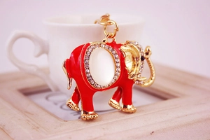 Détail d'un porte-clés éléphant en émail rouge orné de strass et d'une pierre opale