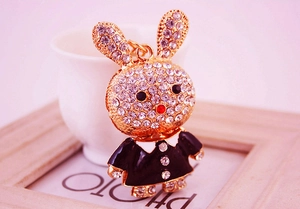 Détail d'un porte-clés lapin avec strass blancs et design smoking en émail noir