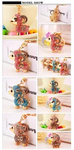 Macro details of cartoon sheep keychain featuring multi-color rhinestones and metal lobster clasp