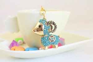 Detail of cute golden sheep keychain with sky blue rhinestones and heart decorations