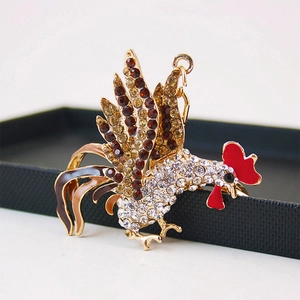 Porte-clés coq étincelant avec placage or et strass colorés sur boîte d'exposition noire