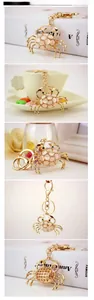 Close-up of golden crab keychain with opal effect stones and sparkling rhinestones