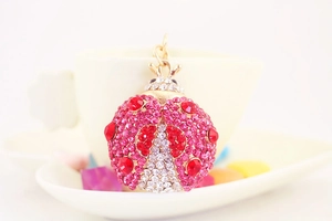 Dettaglio portachiavi a forma di coccinella dorata con strass rosa e rossi brillanti