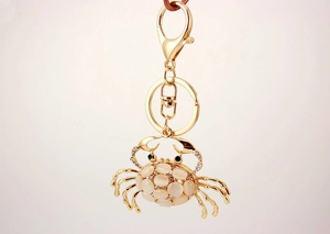 Detailed close-up of golden crab keychain with cat eye stone and sparkling rhinestones