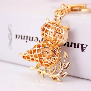 Creative golden owl keychain with hollow-out pattern and sparkling rhinestones