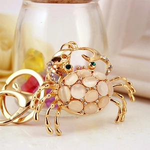 Gold metal crab keychain with white opal stones and sparkling rhinestone accents